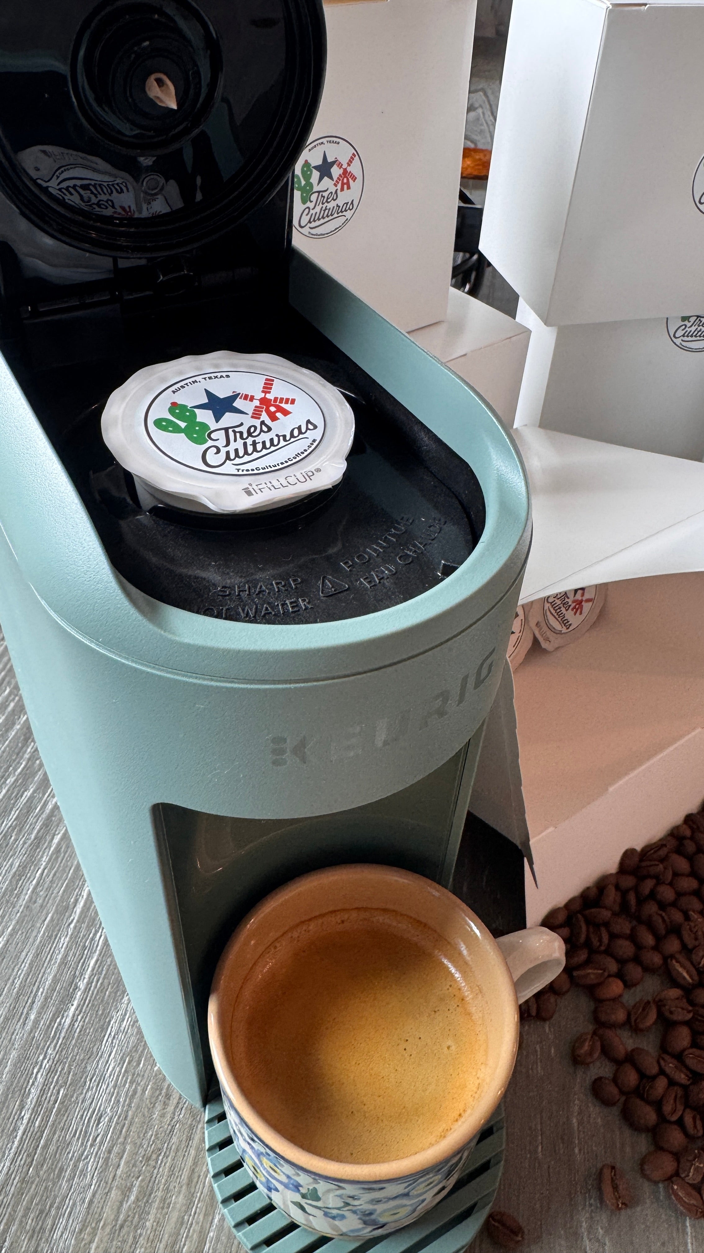 Coffee machine with a cup and coffee beans on a wooden surface